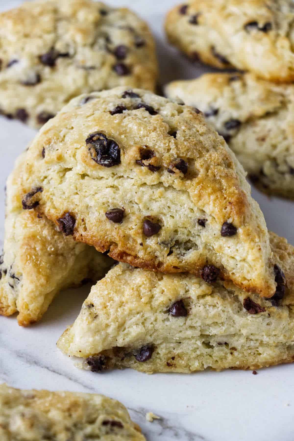 Flaky chocolate chip raisin scones on a counter.