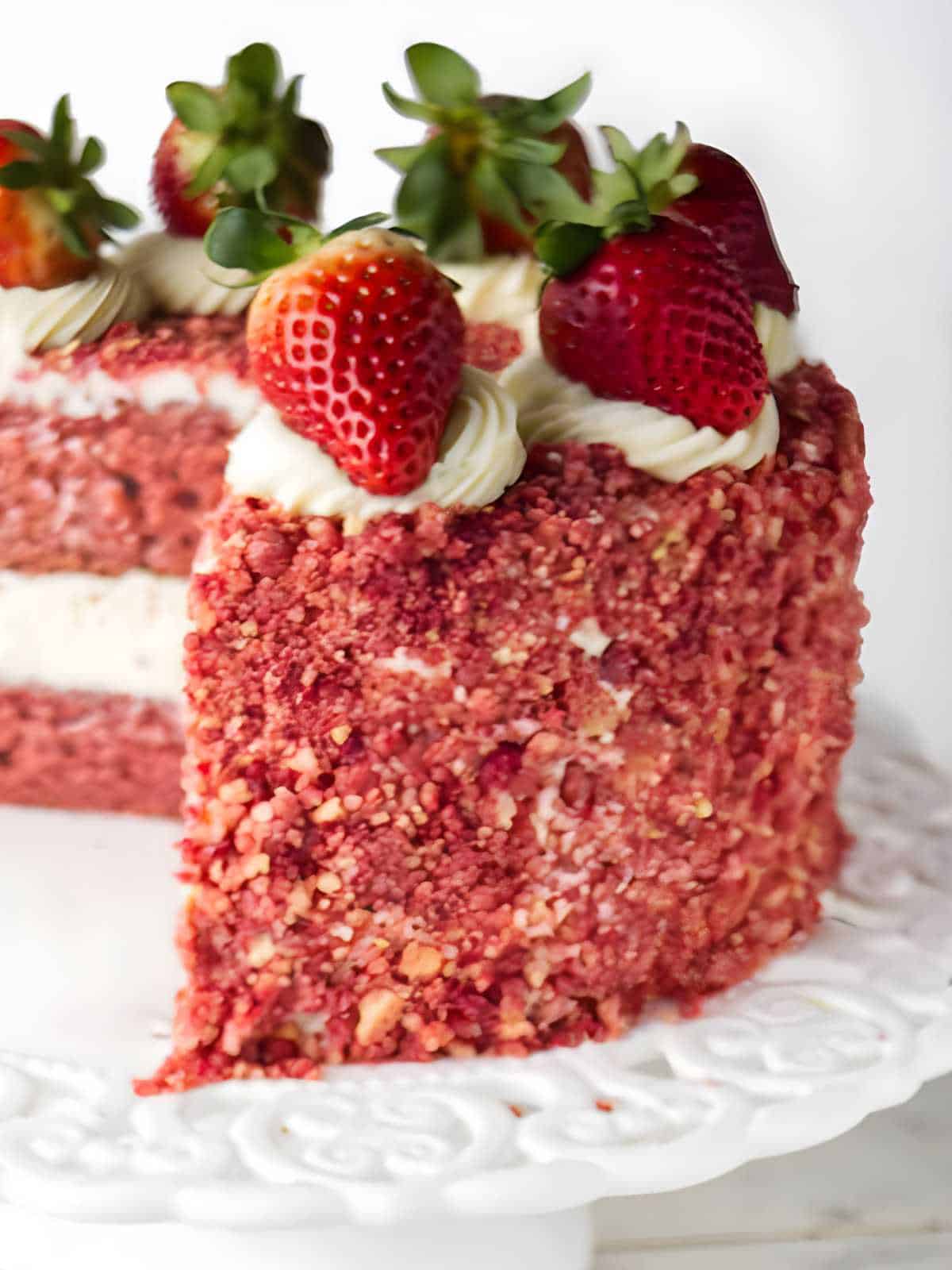 Strawberry crunch cake on a pedestal.