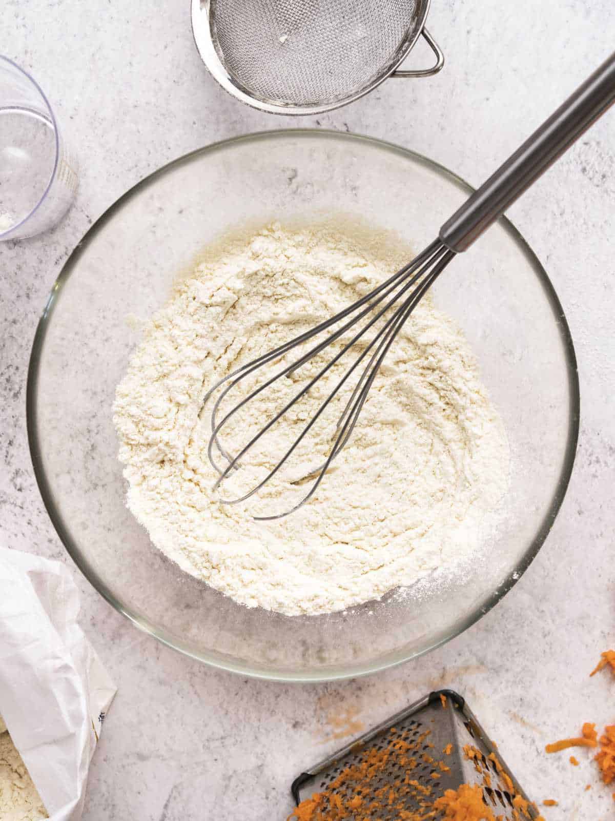 whisking flour together in a mixing bowl.