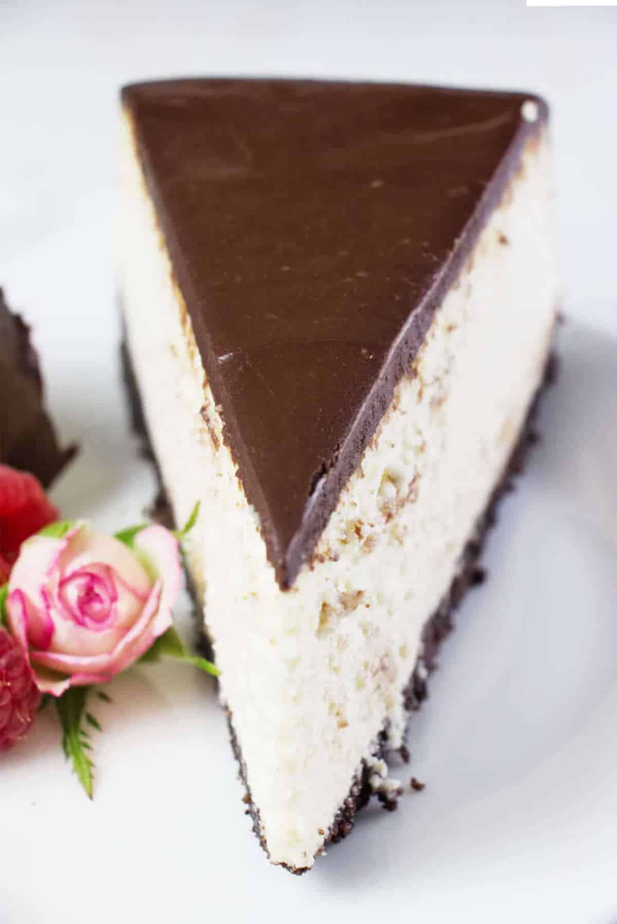 slice of ganache coated vanilla cheesecake.