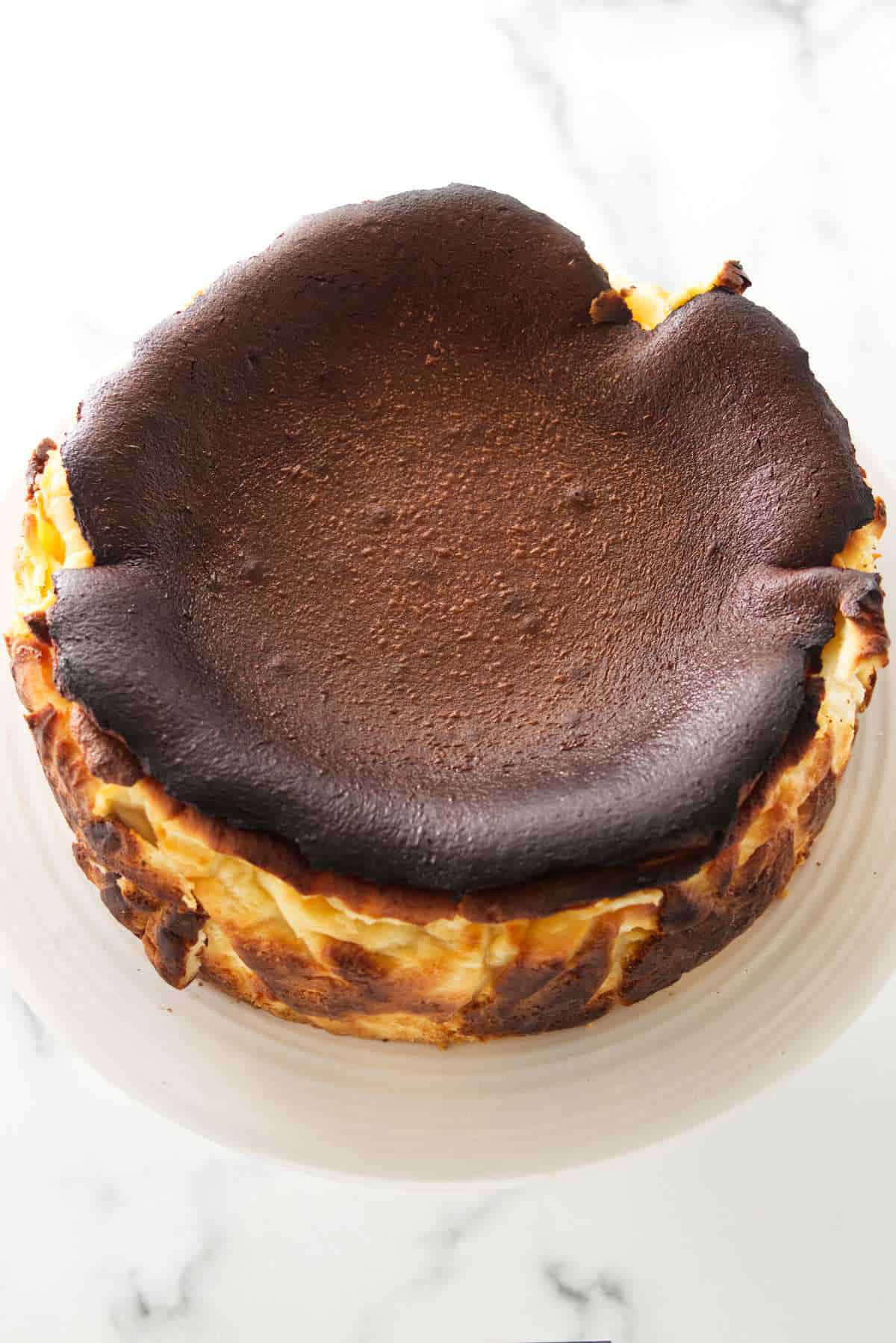 Burnt Basque cheesecake on a cake pedestal.