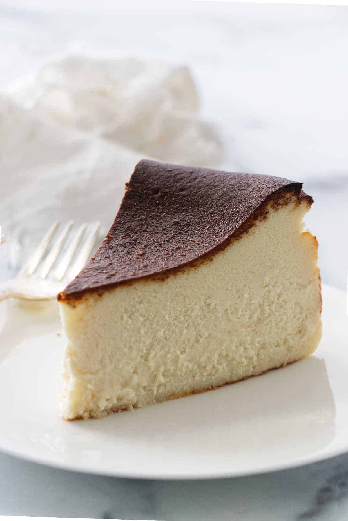 Slice of cheesecake cut from large cake.